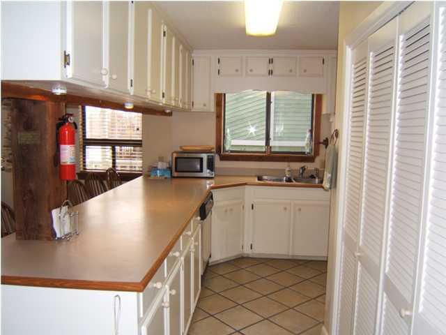 665 Eastern Lake Road Santa Rosa Beach, FL 32459 - Photo 5 of 11 a kitchen with stainless steel appliances granite countertop a sink a stove and a microwave