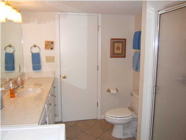 665 Eastern Lake Road Santa Rosa Beach, FL 32459 - Photo 9 of 11 a bathroom with a granite countertop toilet a sink and a mirror