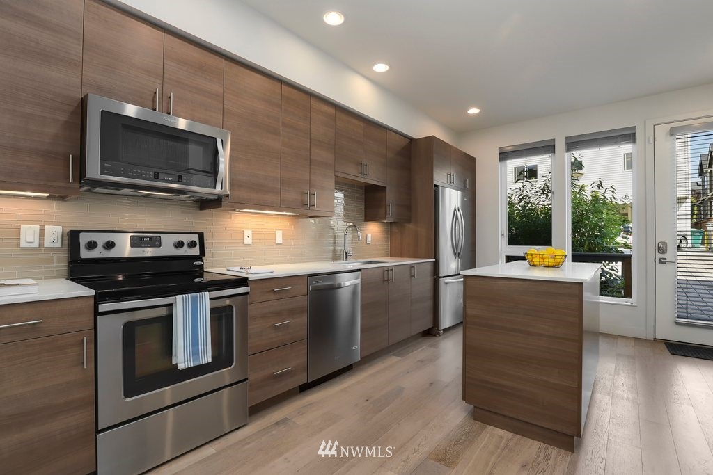 1730 Northwest 60th Street Seattle, WA 98107 - Photo 7 of 25 a kitchen with stainless steel appliances kitchen island granite countertop a stove and a microwave