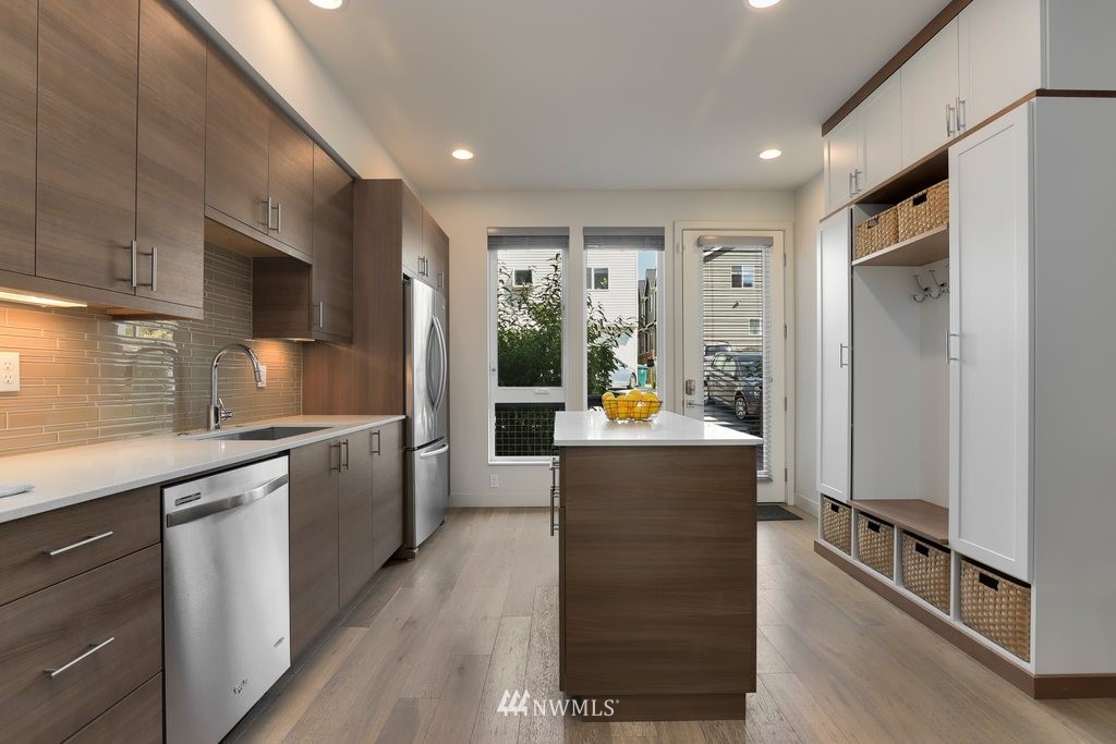 1730 Northwest 60th Street Seattle, WA 98107 - Photo 8 of 25 a view of a kitchen with kitchen island a counter top space a sink stainless steel appliances and cabinets
