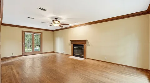 a view of an empty room with a window and a fireplace