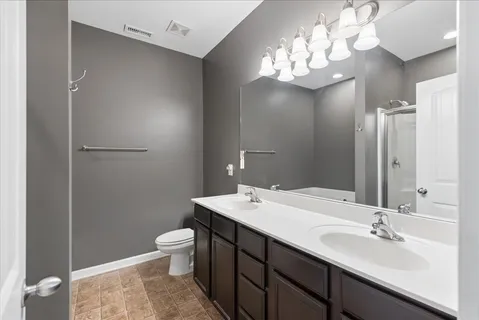 a bathroom with a double vanity sink mirror and toilet