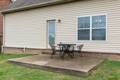 a view of a house with backyard and sitting area