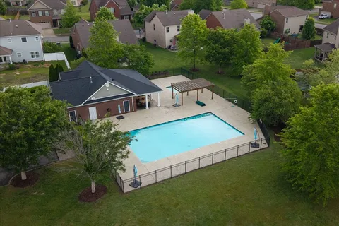 an aerial view of residential house with outdoor space and trees all around