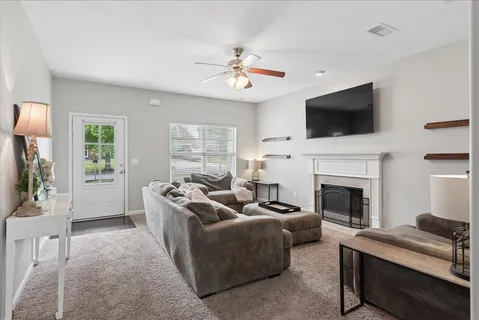 a living room with furniture a fireplace and a flat screen tv