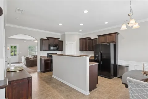 a kitchen with a refrigerator a stove top oven a sink dishwasher and wooden floor