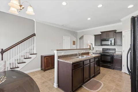 a kitchen with stainless steel appliances granite countertop a stove a sink and a refrigerator