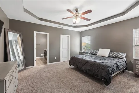 a spacious bedroom with a large bed and a chandelier