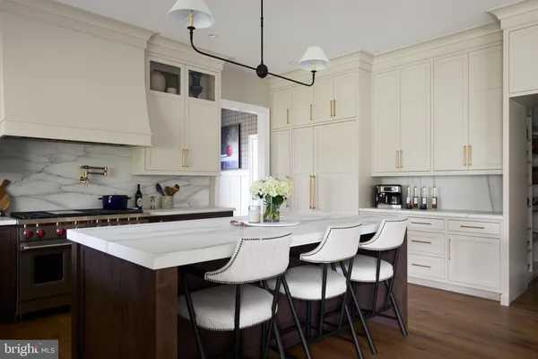 a kitchen with stainless steel appliances a table and chairs in it
