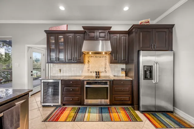 a kitchen with stainless steel appliances granite countertop a refrigerator and a stove