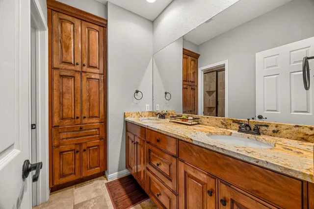a bathroom with a granite countertop sink and a mirror