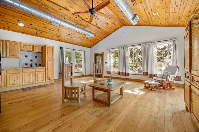 a living room with furniture a wooden floor and pool table