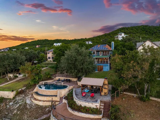 a view of a patio with table and chairs potted plants and a lake view