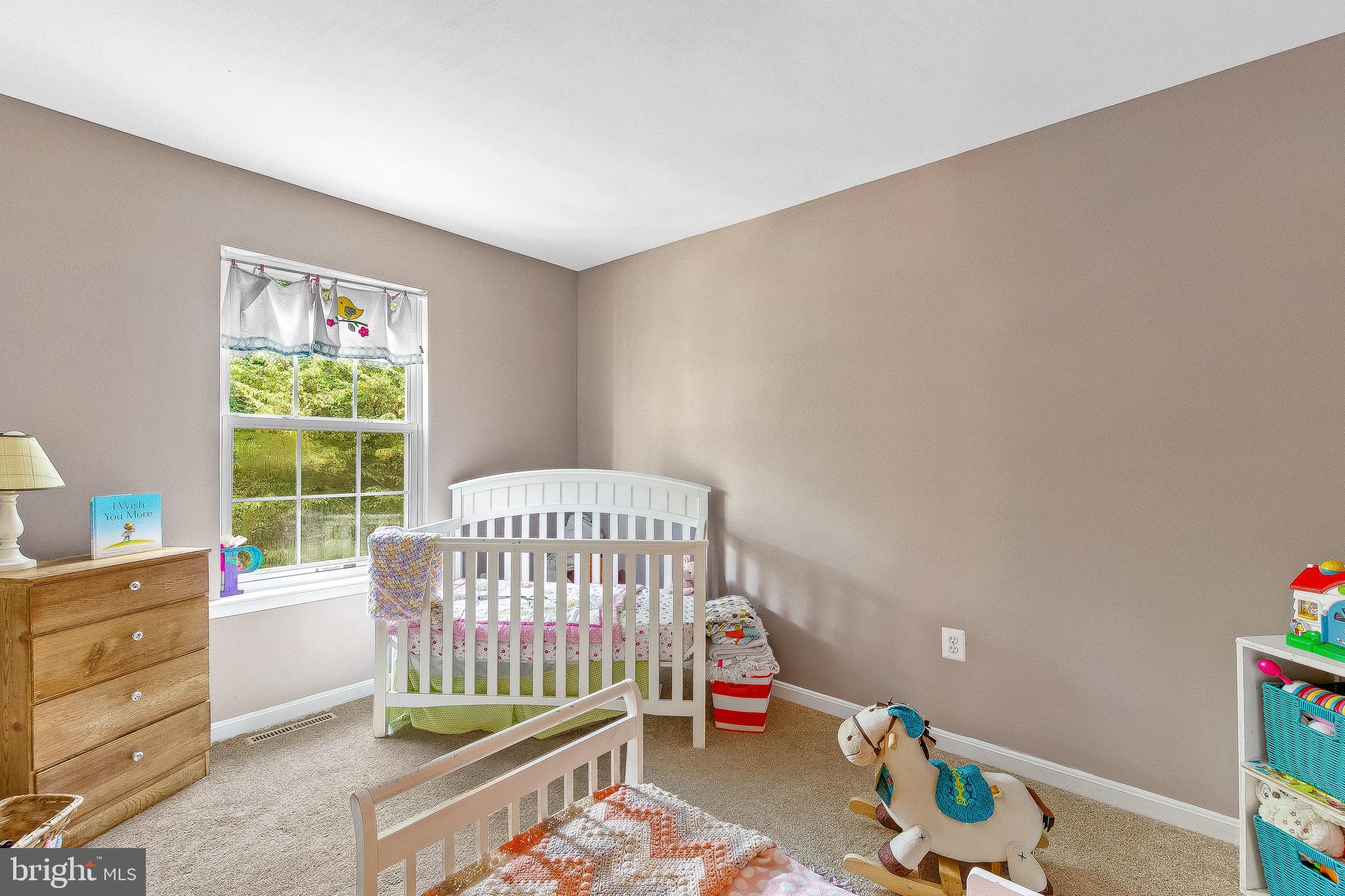 11356 Redlands Road Lusby, MD 20657 - Photo 18 of 36 a bedroom with a baby bed a couch and a window