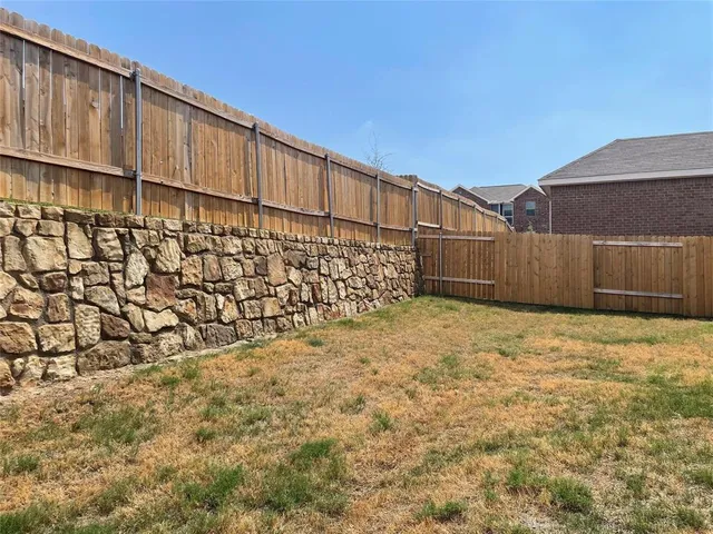 a view of a backyard of wooden fence