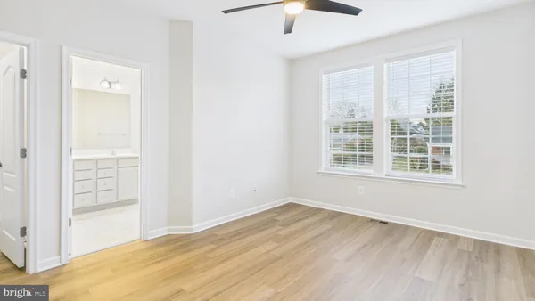 a bathroom with a toilet a sink a mirror a shower a vanity and window