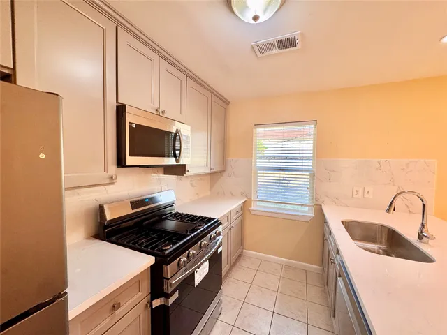 a kitchen that has a sink and a stove top oven