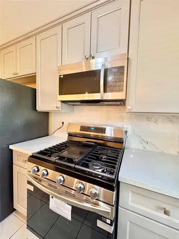 a stove top oven sitting inside of a kitchen