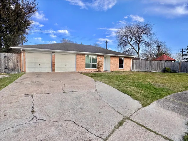 a view of a house with a yard and large tree