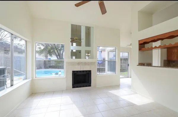 a view of an empty room with a fireplace and a window