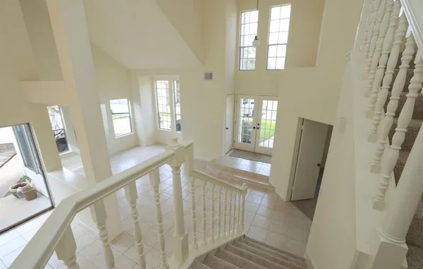 a view of a hallway with wooden floor and stairs