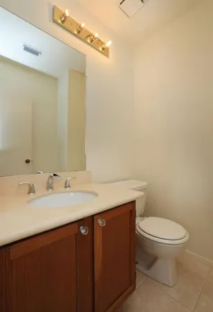 a bathroom with a granite countertop sink a toilet and a mirror