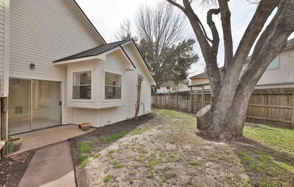 a view of a house with a large tree and a yard