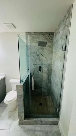 an empty room with wooden floor and fan