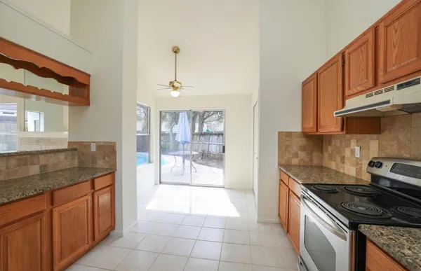 a kitchen with granite countertop a sink and a stove