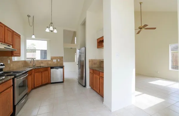 a kitchen with stainless steel appliances granite countertop a sink a stove and a refrigerator