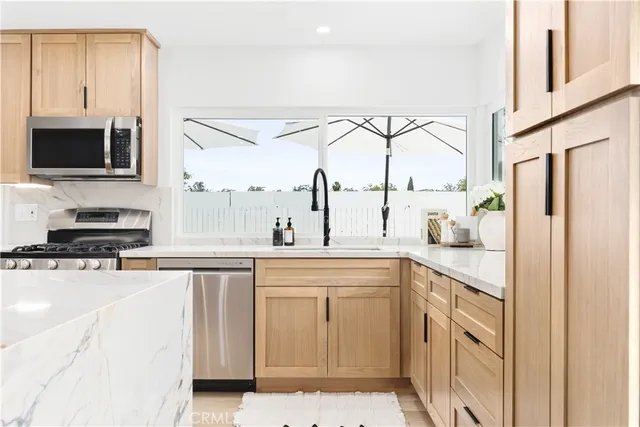 a kitchen with stainless steel appliances granite countertop a stove a sink and a refrigerator