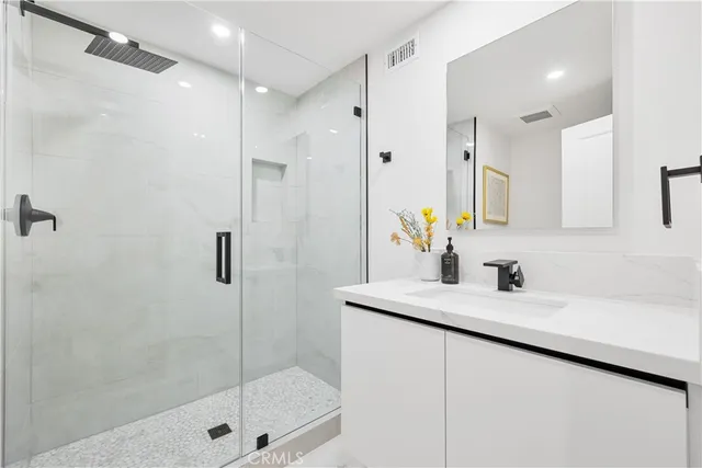 a bathroom with a shower sink and mirror