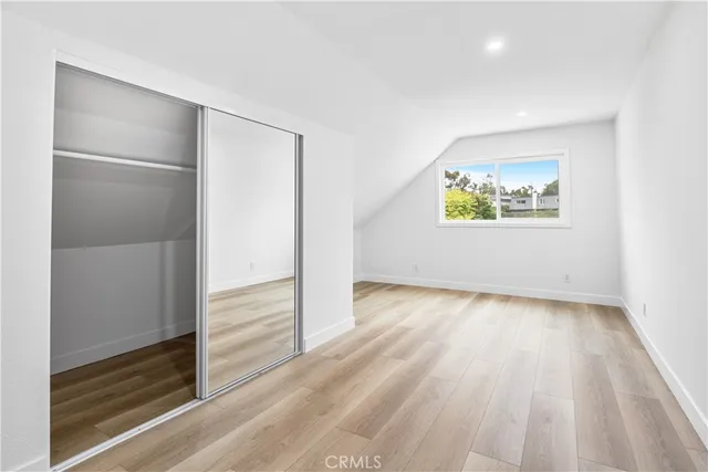an empty room with wooden floor and window