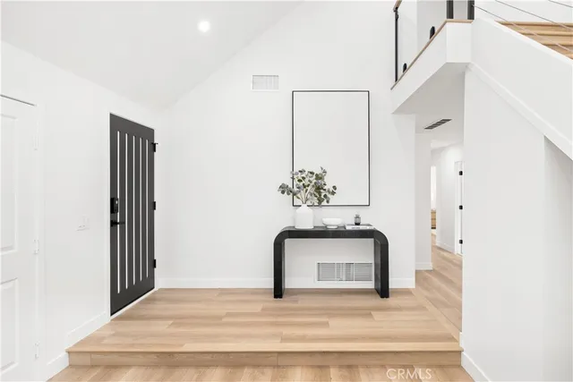 a view of a hallway with wooden floor and a chandelier