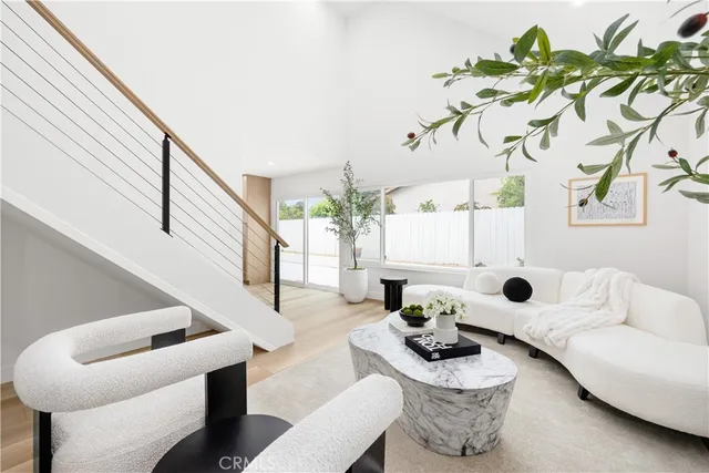 a living room with furniture flowers and a potted plant