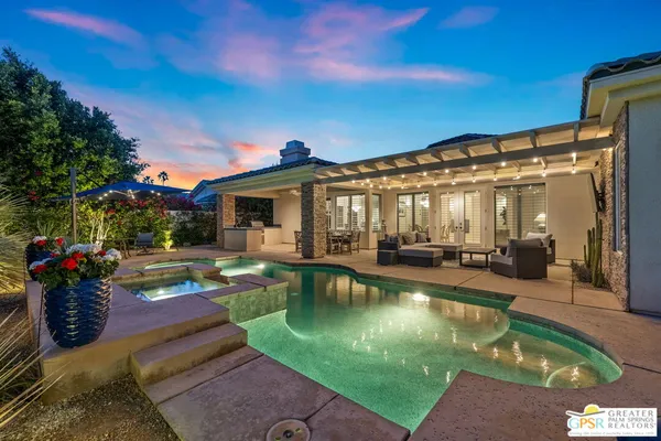 a view of a house with swimming pool and sitting area