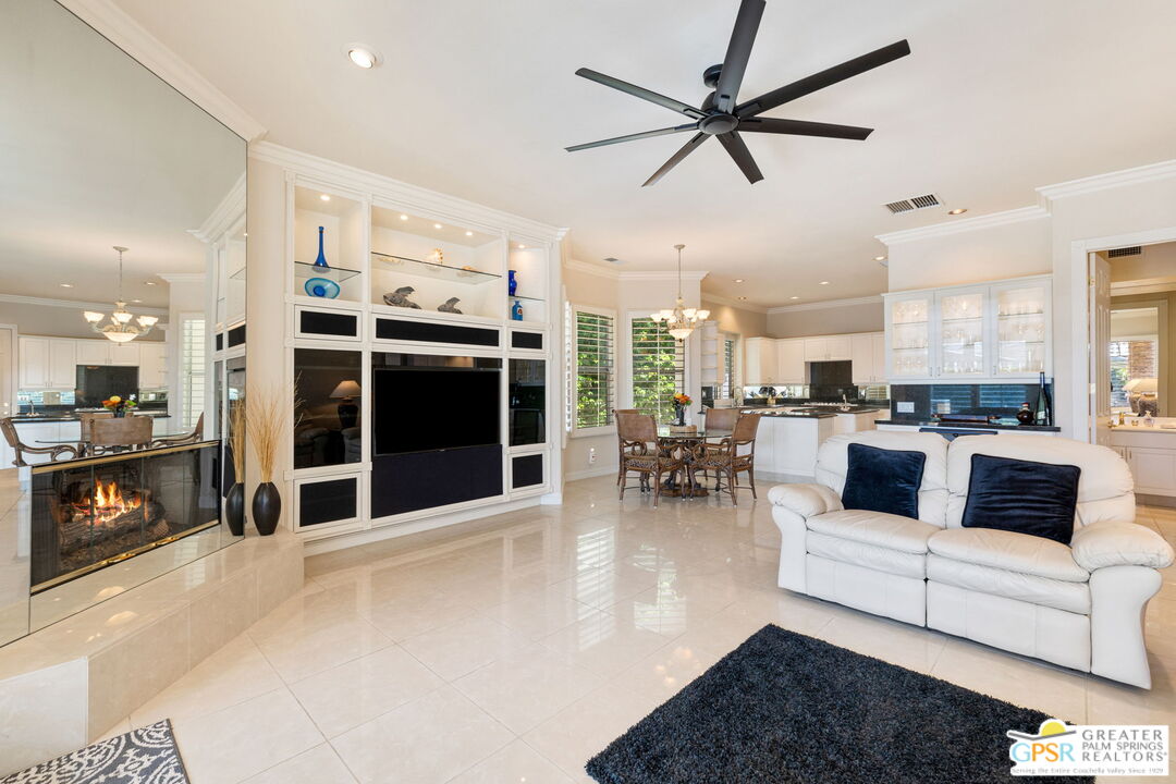 51 Killian Way Rancho Mirage, CA 92270 - Photo 23 of 71 a living room with furniture a ceiling fan and a fireplace