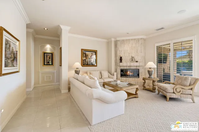 a spacious bedroom with a large bed chandelier and a window