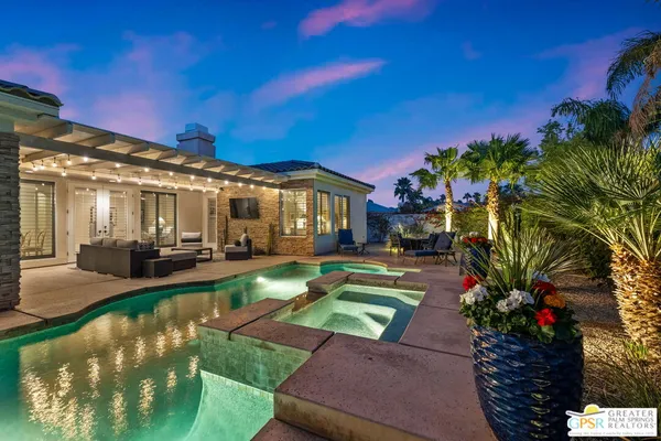a view of a patio with table and chairs and floor to ceiling window and potted plants