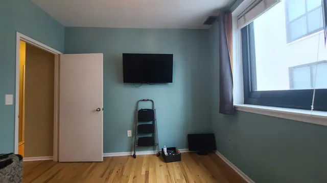 a view of a livingroom with wooden floor and a flat screen tv