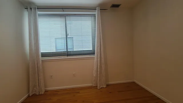 a view of a small space with wooden floor and a window