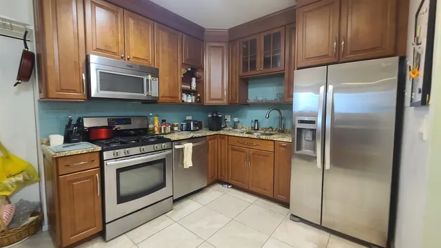 a kitchen with stainless steel appliances granite countertop a refrigerator sink and cabinets