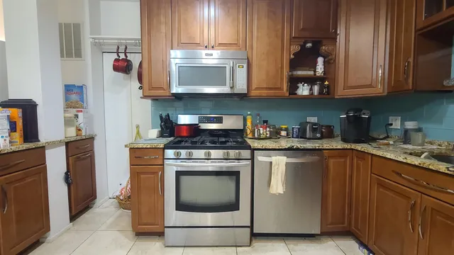 a kitchen with stainless steel appliances granite countertop a stove and a microwave