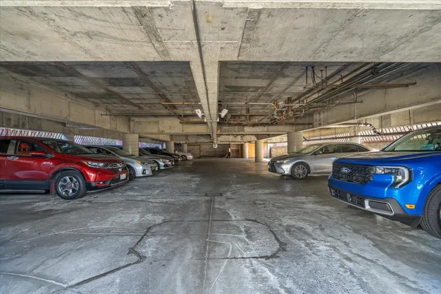 a view of parking garage with cars parked