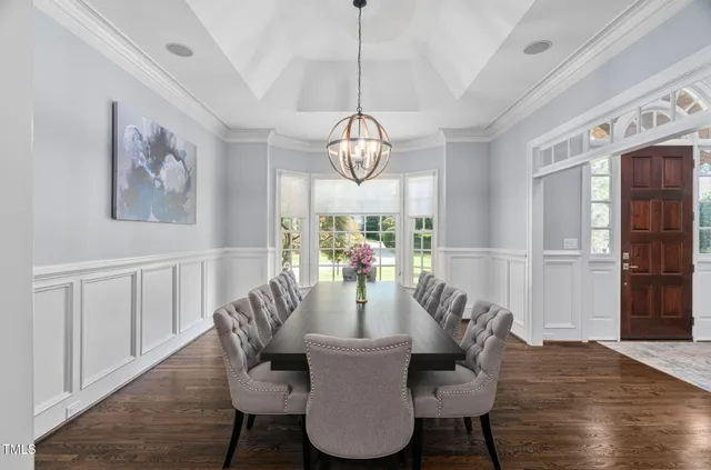 a kitchen with stainless steel appliances kitchen island granite countertop a dining table chairs and white cabinets