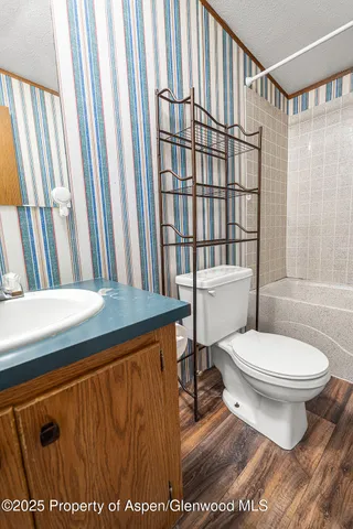 a bathroom with a granite countertop bathtub sink vanity mirror and toilet