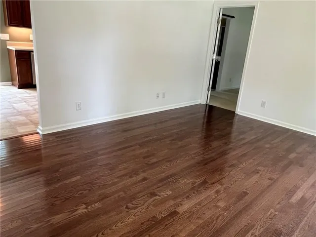an empty room with wooden floor and mirror