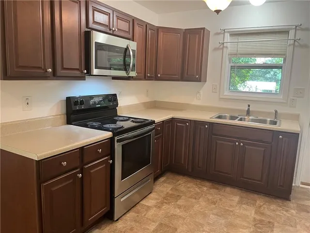 a kitchen with a sink stove and microwave