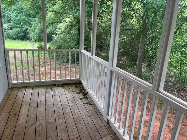 an empty room with wooden floor chandelier fan and window