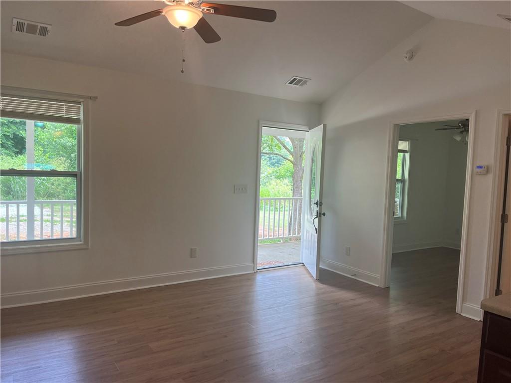 1429 Thyatira Brockton Road Jefferson, GA 30549 - Photo 46 of 46 an empty room with wooden floor chandelier fan and window